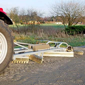 Vägsladd monterad på traktor, visar alla tre skär inklusive det fjärde bestående av strängspridare. 